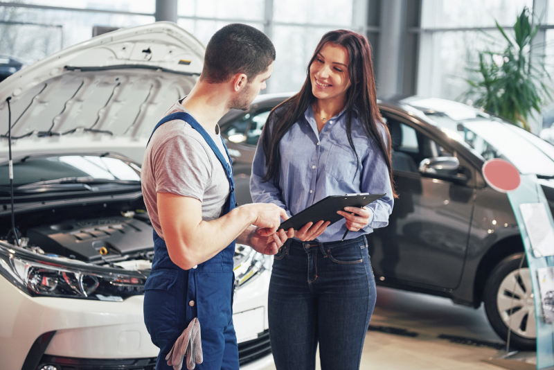 mechanik odovzdáva žene auto, vysvetľuje jeho technický stav